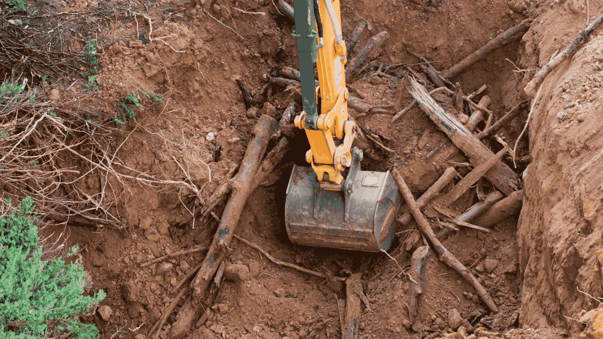 excavation machine picking up some dirt of a field